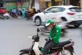 Hanoi, Vietnam - July 7, 2017: Grab motorbike driver waiting for customer on Ba Trieu street. Entered Vietnam in 2014, Grab growin