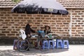 Hanoi, Vietnam - July 16, 2916: Woman who sales stewed fruit, sweetened porridge at stall talking to old man, old brick on backgro