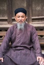 Hanoi, Vietnam - Jun 22, 2017: Old man with ancient feudal traditional long dress Ao Dai for his feudal official role in communal Royalty Free Stock Photo