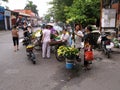 Several women at a flower stall on a street in Hanoi