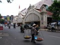 A woman with the typical Vietnamese scale in front of the Dong Xuan market in Hanoi