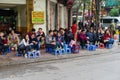 Hanoi, Vietnam - Mar 15, 2015: People drink coffee, tea or juice fruit on cafe stall on sidewalk in Nha Tho street, center of Hano