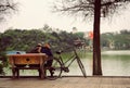 Hanoi, Vietnam - 10 March, 2012: The couple sit on the bench beside their bicycle at Hoan Kiem lake Royalty Free Stock Photo