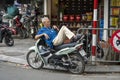 Vietnamese man rest on motorbike taxi on street in old town Hanoi , Vietnam