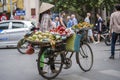 Vietnamese woman with bike selling tropical fruit on the street food market of old town in Hanoi, Vietnam