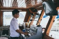 Hanoi, Vietnam - May 2019: captain behind ferry wheel cruising Halong bay