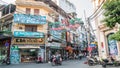 View of busy traffic with motorbikes and vehicles in Hanoi Old Quarter, capital of Vietnam. People can seen exploring around it. Royalty Free Stock Photo
