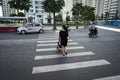 Hanoi, Vietnam - Oct 19, 2016: Mother with a baby stroller crossing the street in Minh Khai. Vehicles running on street.