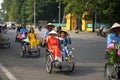 Hanoi, Vietnam - Oct 16, 2016: Vietnamese girl wears traditional long dress Ao Dai going by Cyclo pedicab on Hanoi street Royalty Free Stock Photo