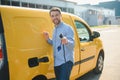 Hansome bearded guy near his new modern electric car at the charging station