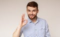 Hansome guy showing gesture and smiling on background