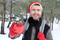 Hansome man holding Christmas present in the snow