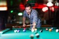 Hansome man playing pool in bar alone