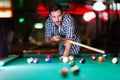 Hansome man playing pool in bar alone