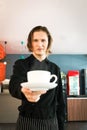 Hansome young man barista holding a cup of hot coffee in the cafe shop, waiter staff serving coffee to customer in coffee shop Royalty Free Stock Photo