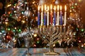 Hanukkah background with menorah and burning candles on sparkle background with defocused lights Royalty Free Stock Photo