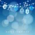 Hanukkah blue background with string of lights, dreidels and jewish stars.