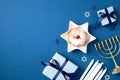 Hanukkah celebration flat lay with golden menorah, candles, sufganiyot, and gift boxes. Happy Chanukah greeting card with Jewish