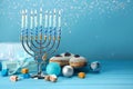 Hanukkah celebration. Menorah with burning candles, dreidels, gift boxes and donuts on light blue wooden table, space for text Royalty Free Stock Photo