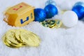 Hanukkah decorations including gelt, sparkly ornaments and a dreidel in snow. Royalty Free Stock Photo