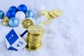 Hanukkah decorations including gelt, sparkly ornaments and a dreidel in snow. Royalty Free Stock Photo