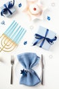 Hanukkah dinner table top view. Flat lay plate with napkin and cutlery, gold menorah with blue candles, gift boxes, david star Royalty Free Stock Photo