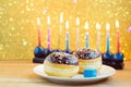 Hanukkah holiday sufganiyot with menorah on wooden table