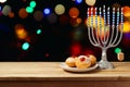 Hanukkah holiday sufganiyot with menorah on wooden table Royalty Free Stock Photo