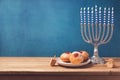 Hanukkah holiday sufganiyot and menorah on wooden table