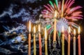 Hanukkah menorah with candles, colorful firework sky background