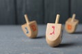 Hanukkah traditional dreidel with letter Gimel on grey wooden table, closeup. Space for text Royalty Free Stock Photo