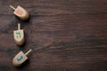 Hanukkah traditional dreidels with letters He, Pe and Nun on wooden table, flat lay. Space for text Royalty Free Stock Photo