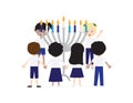 Jewish kids holding hands and standing around large Hanukkah menorah