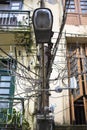 Haphazard disorganized chaotic power cables running along street lightings in Yangon Myanmar Burma