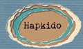 Hapkido - typewritten word in ragged paper hole background Korean martial art- concept tattered illustration