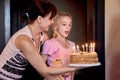 The happiest family.A girl tries to blow out the candles on the cake