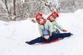 Sisters twins are sitting on the boy`s back and sledging Royalty Free Stock Photo