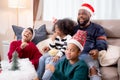 Happiness African family mom and dad and daughter watching tv and laughing with fun and enjoyment.