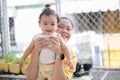 Happiness Asian mother holding a cute little baby girl on blurred background , baby smile and looking at camera