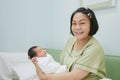 Happiness Asian mother with smiley face holding her newborn baby and look at camera, baby and mother concept Royalty Free Stock Photo