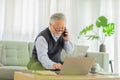 Happiness Asian senior handsome business man with white hairs hold mobile phone and using computer laptop talking with business Royalty Free Stock Photo