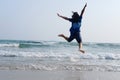 Happiness of Asian woman is jumping on sky with sea and wave on the sand beach in natural sunset. Freedom lonely life on vacation Royalty Free Stock Photo
