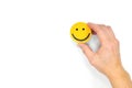Happiness and be positive concept. Male hand holding yellow smiling face in white background with copy space.