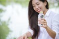 Happiness Beautiful asian chinese women holding mineral water bottle. Young Woman Drinking Water from bottle in green garden Park Royalty Free Stock Photo