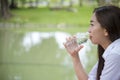 Happiness Beautiful asian chinese women holding mineral water bottle. Young Woman Drinking Water from bottle in green garden Park Royalty Free Stock Photo