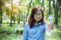 Happiness Beautiful asian chinese women holding mineral water bottle. Young Woman Drinking Water from bottle in green garden Park Royalty Free Stock Photo