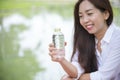 Happiness Beautiful asian chinese women holding mineral water bottle. Young Woman Drinking Water from bottle in green garden Park Royalty Free Stock Photo