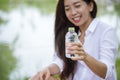 Happiness Beautiful asian chinese women holding mineral water bottle. Young Woman Drinking Water from bottle in green garden Park Royalty Free Stock Photo