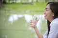 Happiness Beautiful asian chinese women holding mineral water bottle. Young Woman Drinking Water from bottle in green garden Park Royalty Free Stock Photo