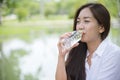 Happiness Beautiful asian chinese women holding mineral water bottle. Young Woman Drinking Water from bottle in green garden Park Royalty Free Stock Photo